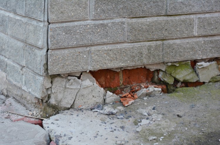 Cracked foundation wall and crumbling bricks, warning sign by Case Foundation Systems